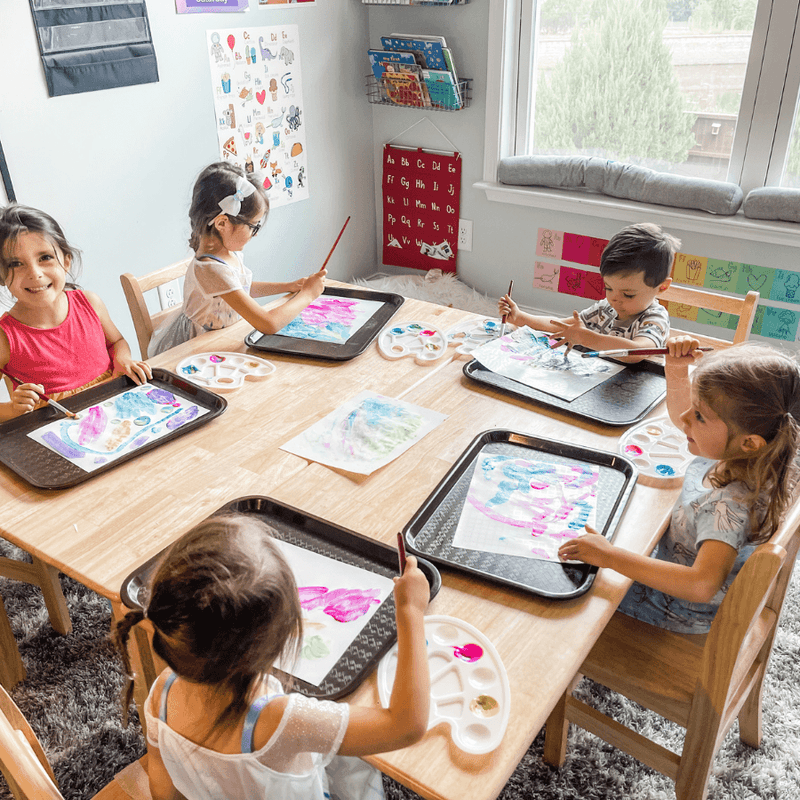 preschool children painting at a table